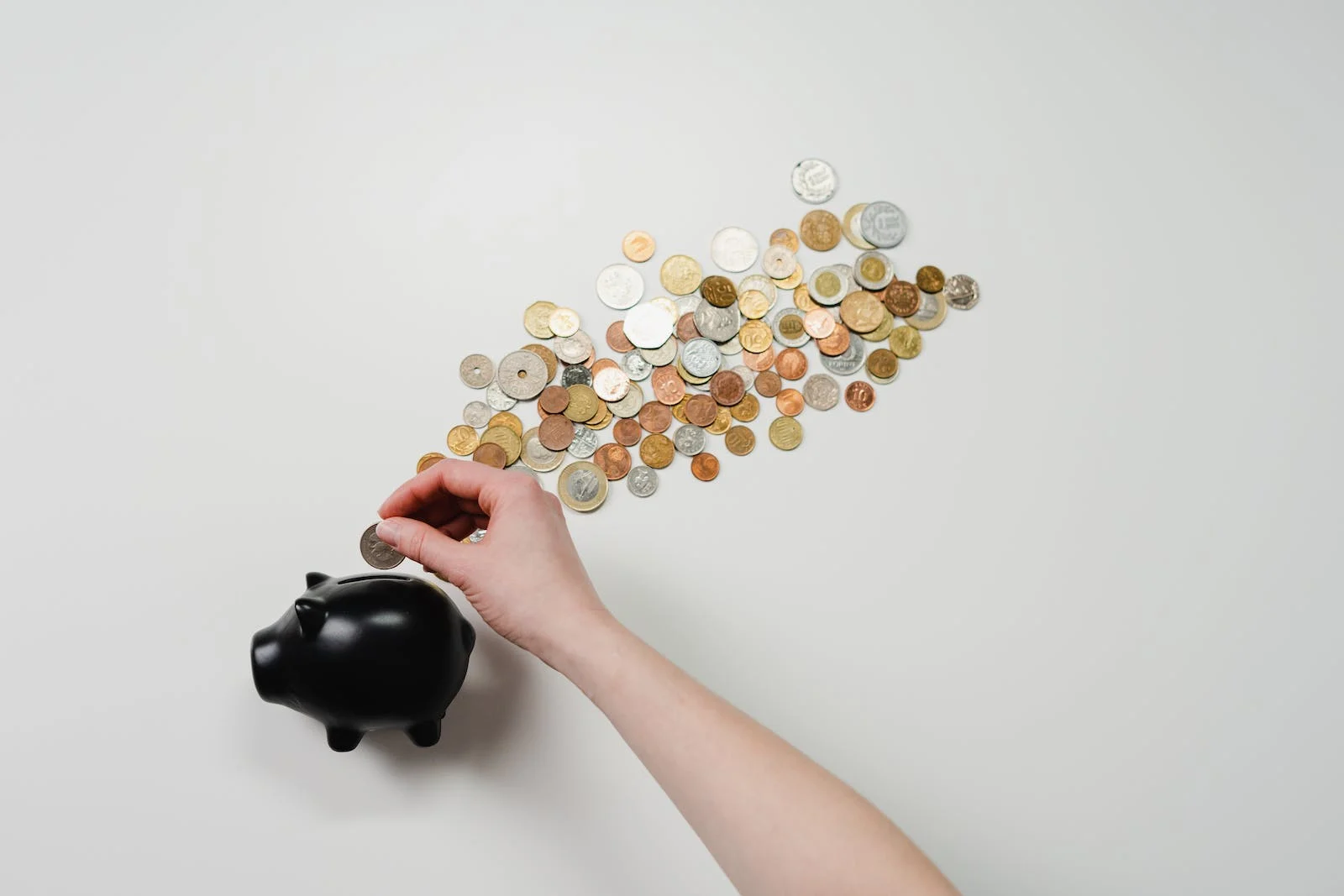 Piggy bank beside a pile of coins.