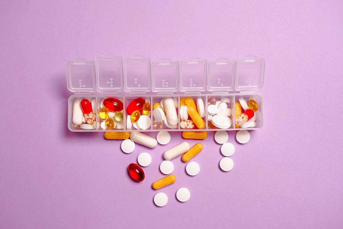 A pill organiser filled with different types of vitamin tablets.