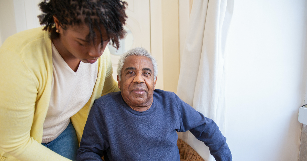 An elderly gentleman being cared for by a younger lady.