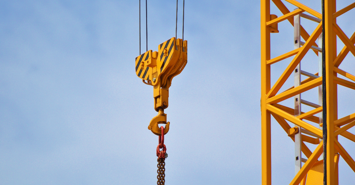 A yellow crane pictured on a blue sky background.