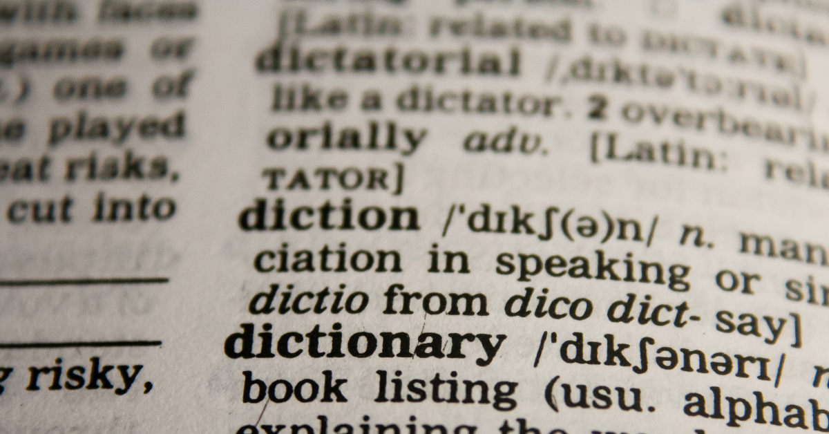 A page of a dictionary, with the words "diction" and "dictionary" visible in the foreground of the page.