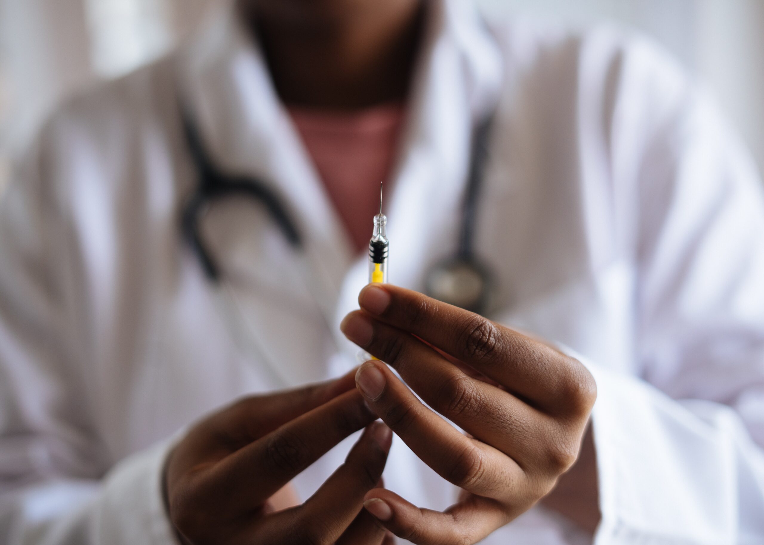 Doctor holding a full syringe.