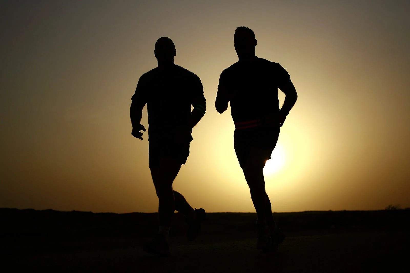 Silhouette of two runners.