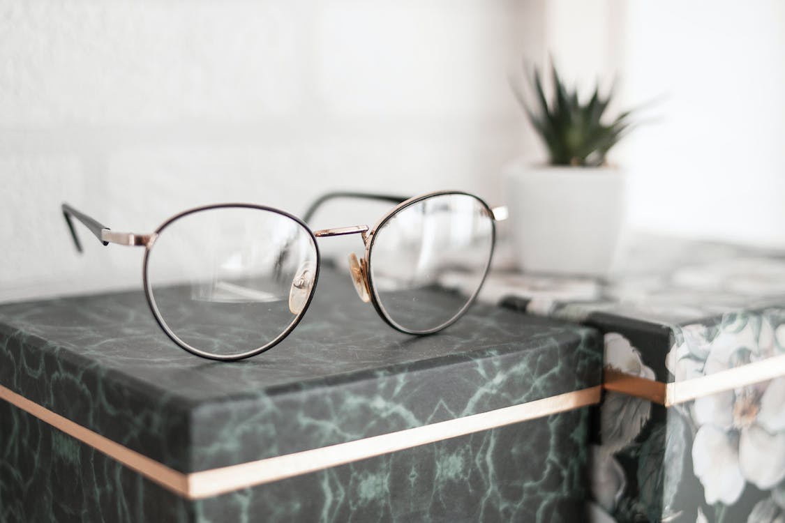 Spectacles resting on a green storage box.