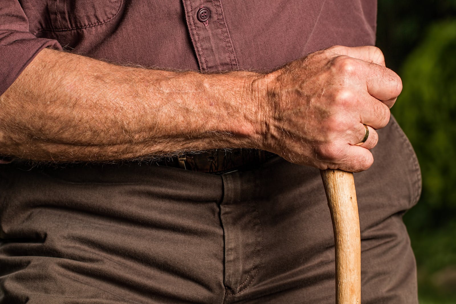 A man grasping a walking stick.