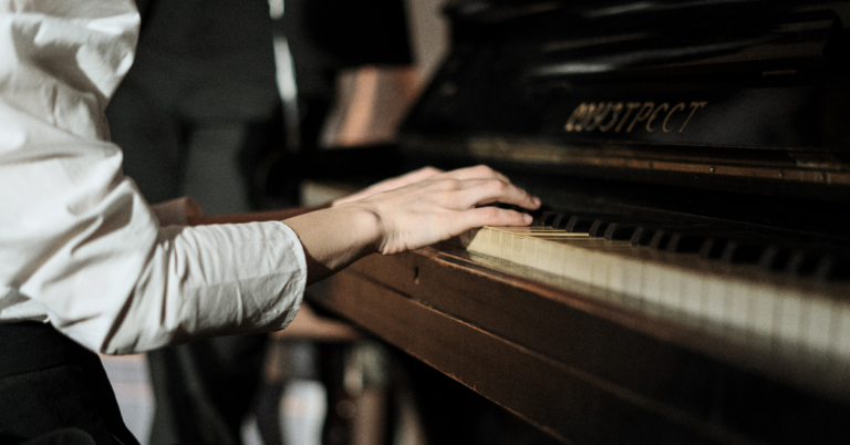 A hand placed on the keys of a piano.